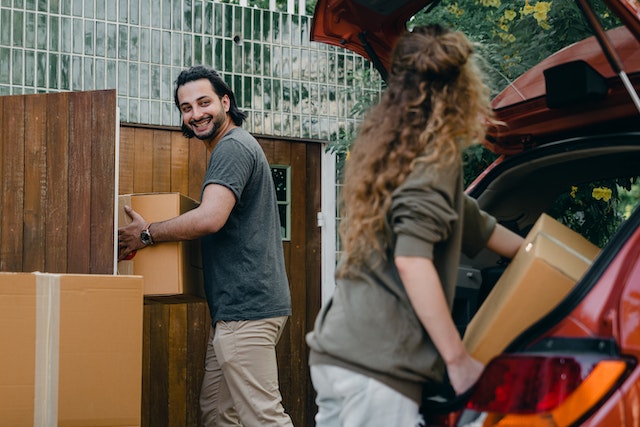 Couple loading their car with boxes before moving from Toronto to Montreal on a short timeline.